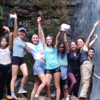 students beneath waterfall