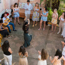 LITA students stand in a circle around a female Flamenco dancer and watch her dance to a guitar accompaniment