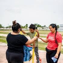Women playing with children on a playground