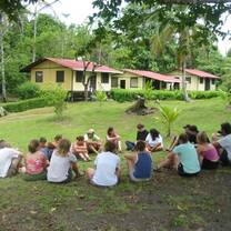 Students sitting in a circle on the grass at a field research station