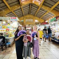 three interns at a market holding fans