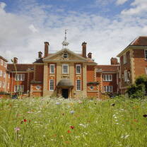 Talbot Hall at LMH Oxford with a meadow of wild flowers