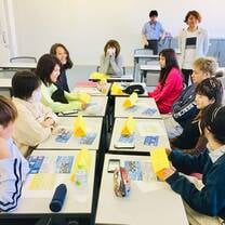 8 students and their desk clustered in a group to facilitate language exchange.