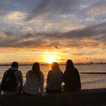 A group looks out towards a sunset