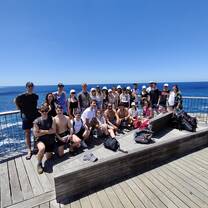 A group poses for a photo on a boardwalk 