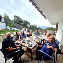 group having dinner around a table on a patio