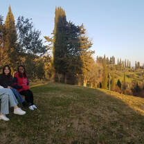 Students sitting outside on a bench taking in a view of the Italian Countryside