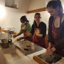 Students participating in a traditional Italian cooking class.