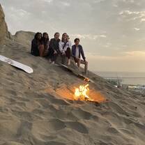 Volunteers rest near a campfire after sandboarding near Trujillo, Peru.