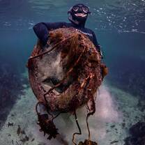 Freediver colecting trash