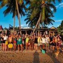 a group poses for a photo on a beach