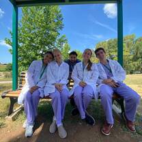 Shadowing Students Relaxing and Enjoying Themselves While Sitting Outside on a Bench 