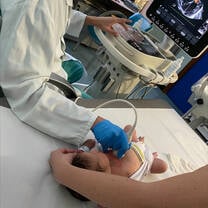 Student Shadowing Pediatrician Performing Ultrasound on a Newborn