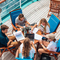 Students studying by the ocean water