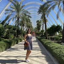 Ashley, an RVF International participant, strolling through the palm-lined walkway at the City of Arts and Sciences in Valencia, Spain, showcasing the vibrant travel and cultural experiences of the Teach English in Spain program