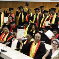 Happy graduating students wearing black, red, and yellow robes and holding their certificates at European Business University of Luxembourg.