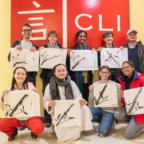 students holding calligraphy work
