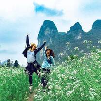 two friends playing in a green field in guilin