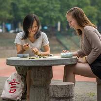 student and teacher learning chinese outdoors