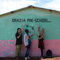 Three people showing a school building