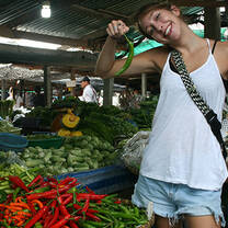 a teacher poses with a chili in a thailand market