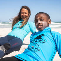 Celilne, Director of Surfpop, assisting during a surf session.