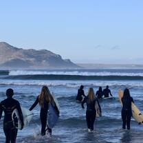 Volunteers brave the Atlantic Ocean during a surf tour.
