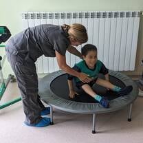 A person helping someone in a trompoline
