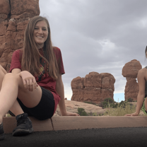Two young women pose in front of rock formations in Utah