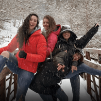 Four young women on a snow-covered foot bridge in Deer Valley, Utah