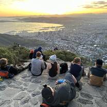 Students watch the sun rise over Cape Town from the summit of Lion's Head Mountain