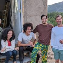 A group of 5 karma yogas celebrating after mudding the outside walls of our new straw bale cabin