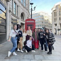 A group photo in front of a classic phone booth