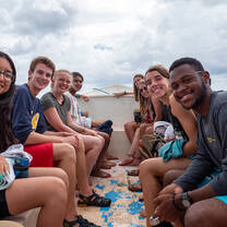 Students in on either side of a small boat