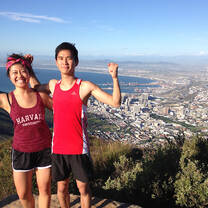 Two students standing on top of a mountain overlooking Cape Town