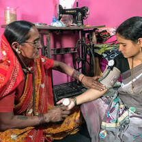 a woman taking another woman's blood pressure 