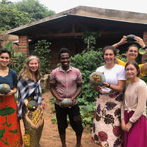 Students wearing traditional Malawian clothing posing for a photo