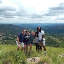 Students posing together at the top of a hill