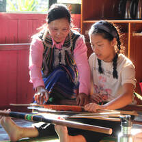 A woman and a girl weaving