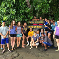 Students posing in front of a sign that reads "Estacion Biologica Campanario"
