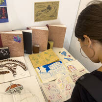 A student looking looking at work displayed during the student art show