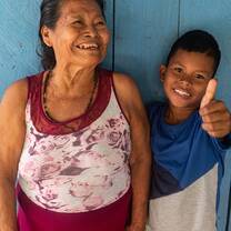 Elderly woman and young boy smile at camera