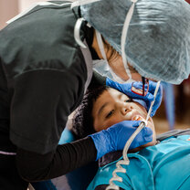 Medical professional provides child with dental service