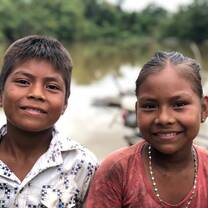 Two children in the Amazon smile at camera