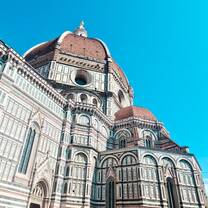 A upward view of the Duomo, surrounded by blue skies 