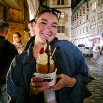 A girl smiles with a dessert 