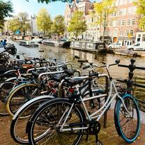 Bikes lined up along a sunny canal 