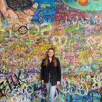 A girl smiling in front of a vibrant wall