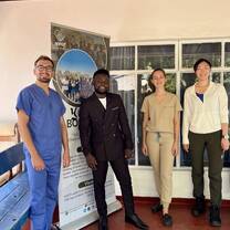four members of the medical team standing in front of a large banner