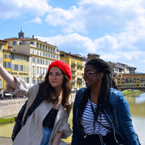 Two students taking a selfie with Ponte Vecchio in background.